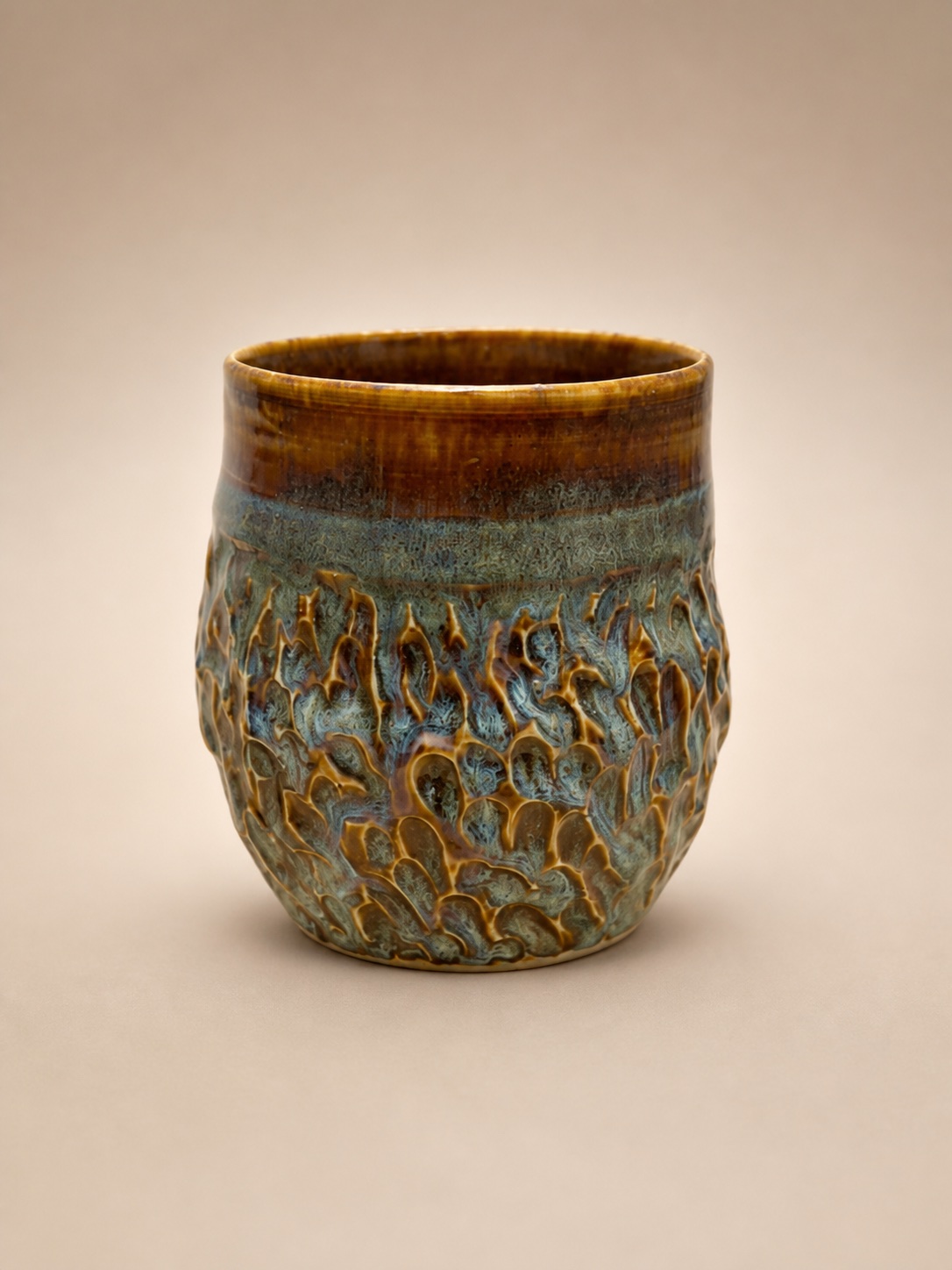 A carved ceramic mug.