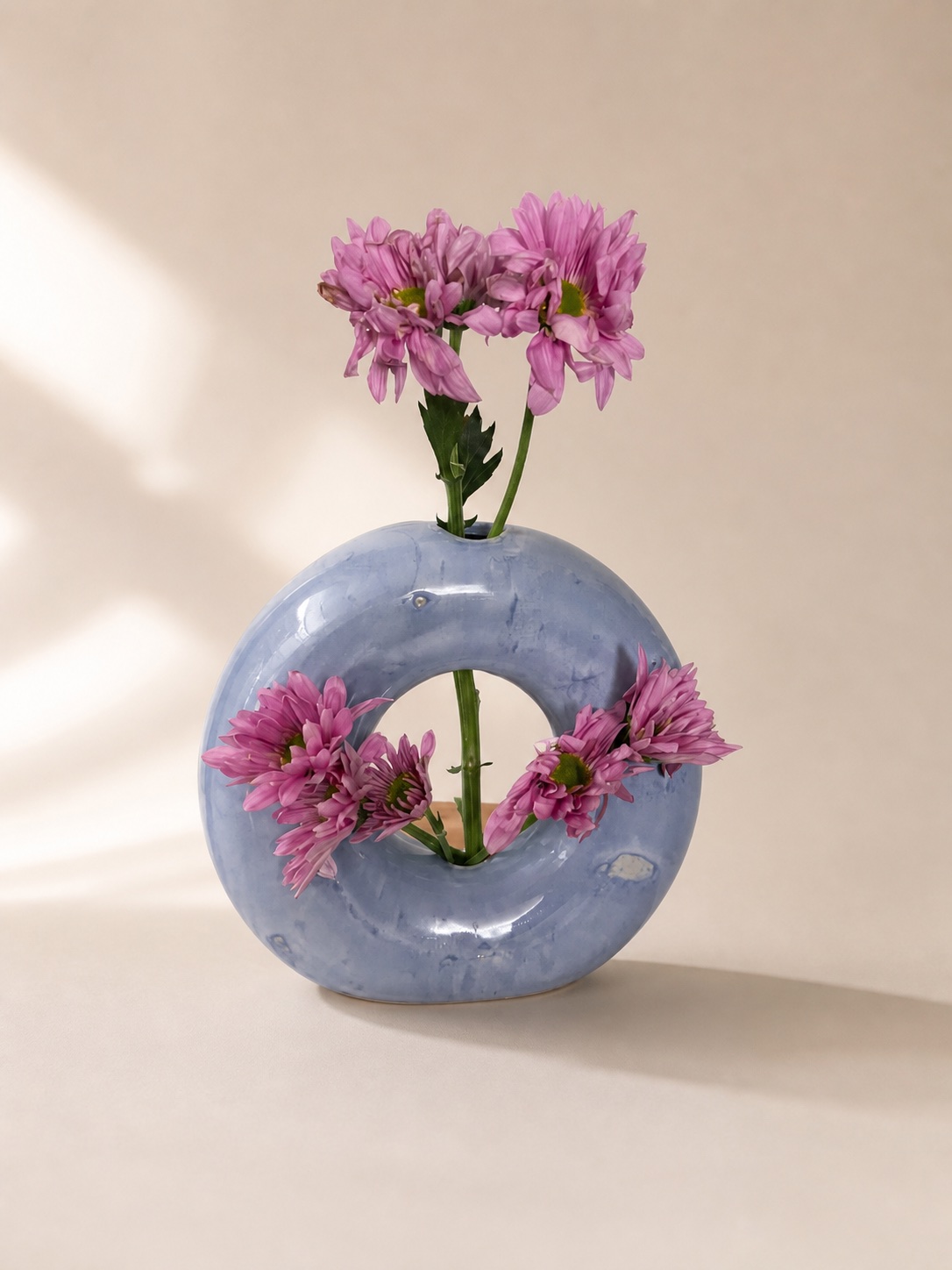 A donut-shaped vase with flowers.