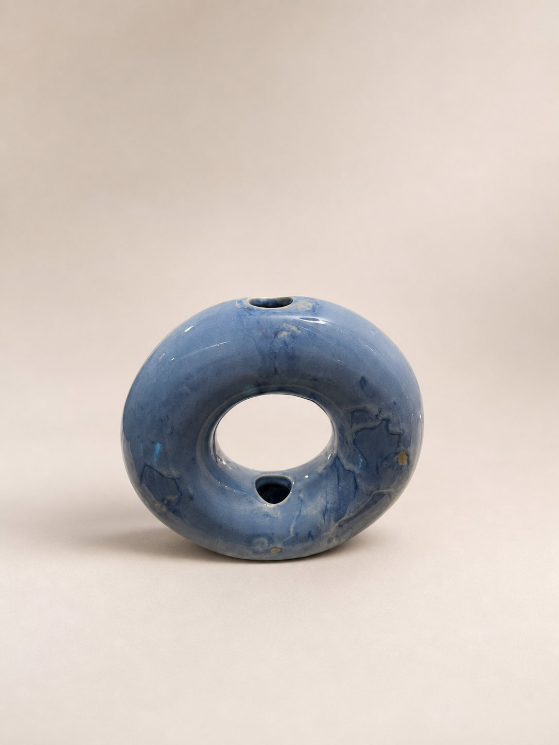A small blue ceramic donut vase.