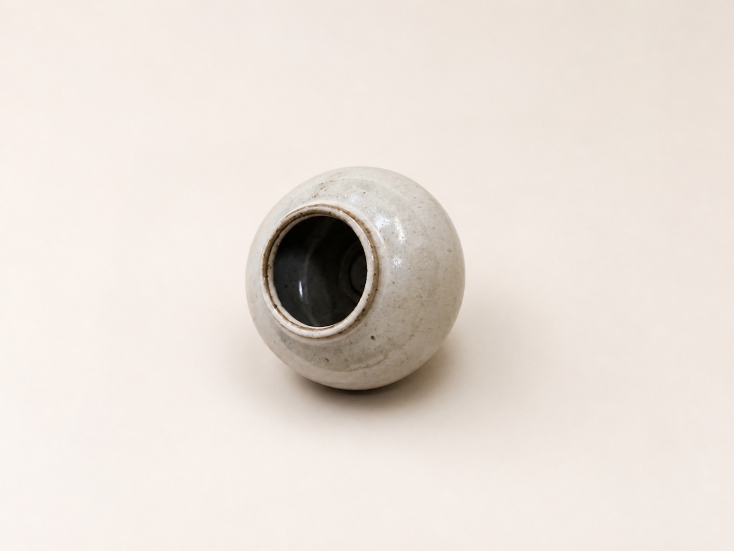 A small pale orb-shaped vase.