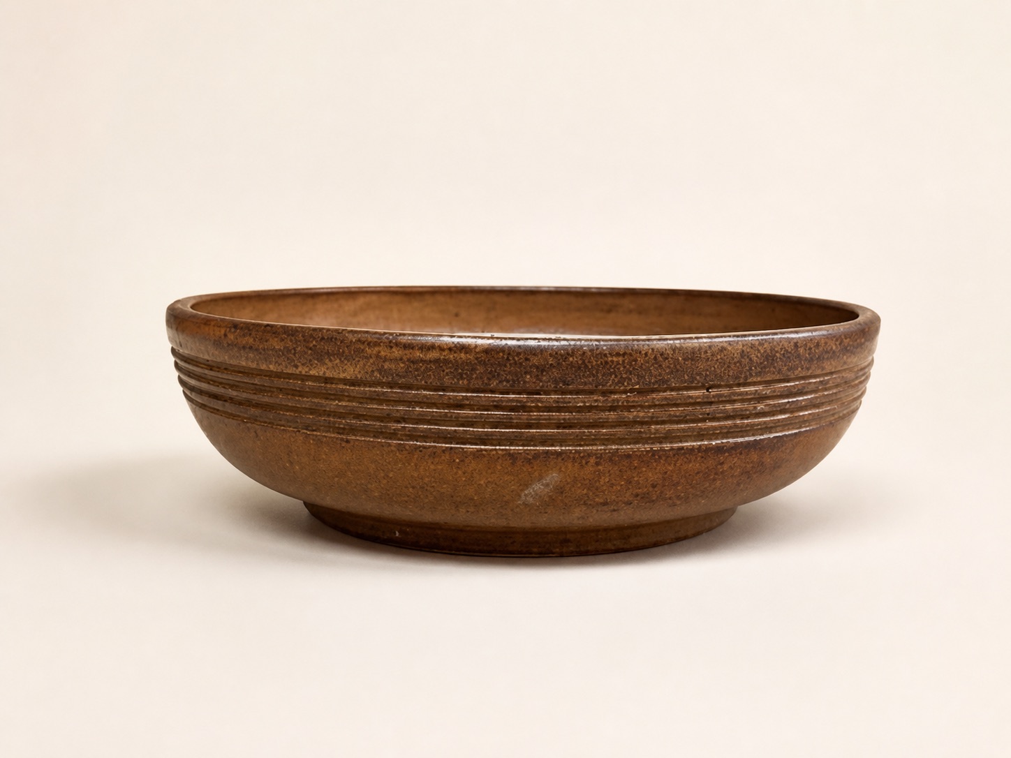 A low brown serving bowl with horizontal ridges.