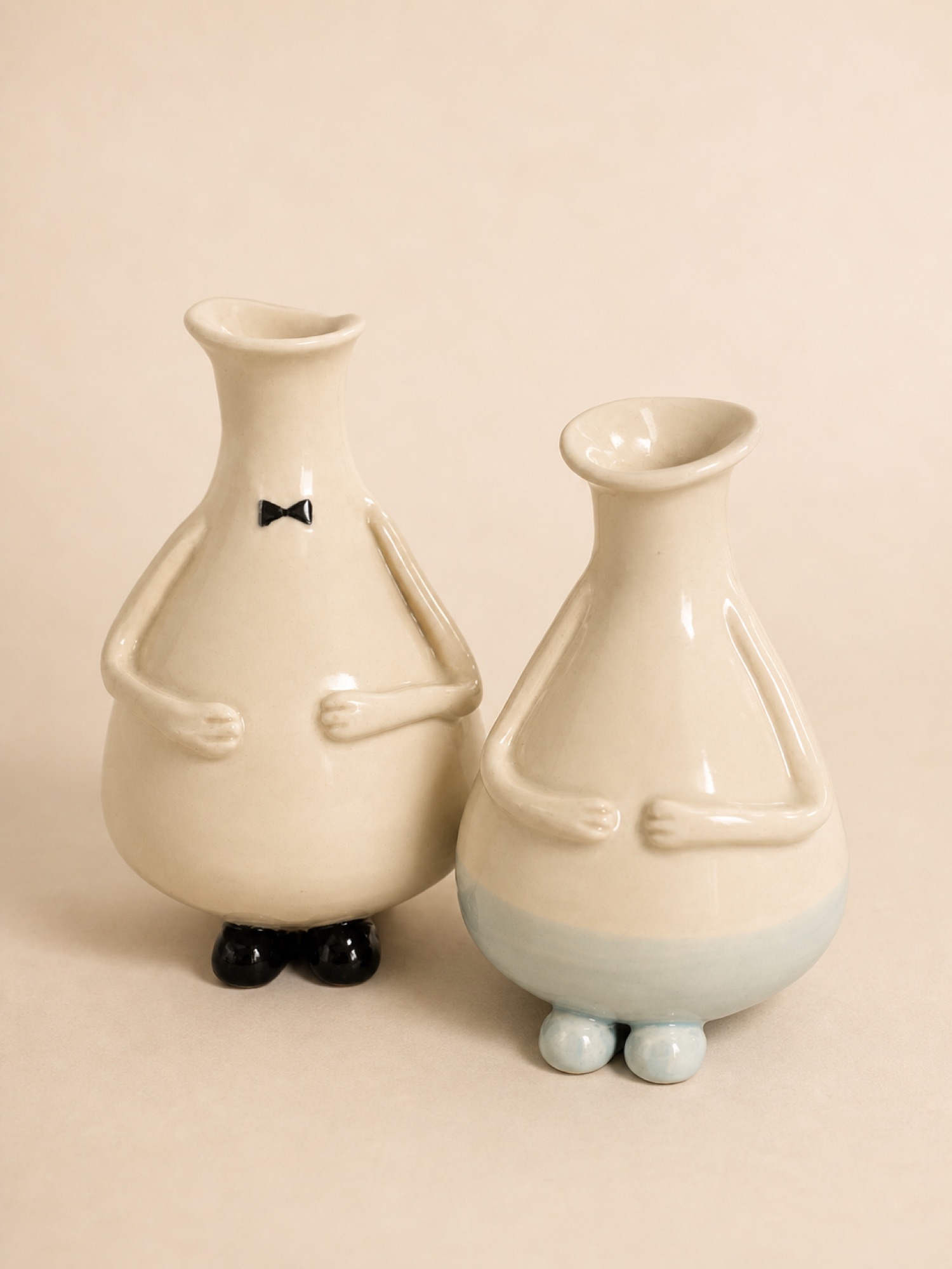 Two cream Azorks, one wearing a black bow tie.
